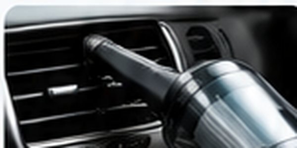Mini aspirador próximo às saídas de ar do carro